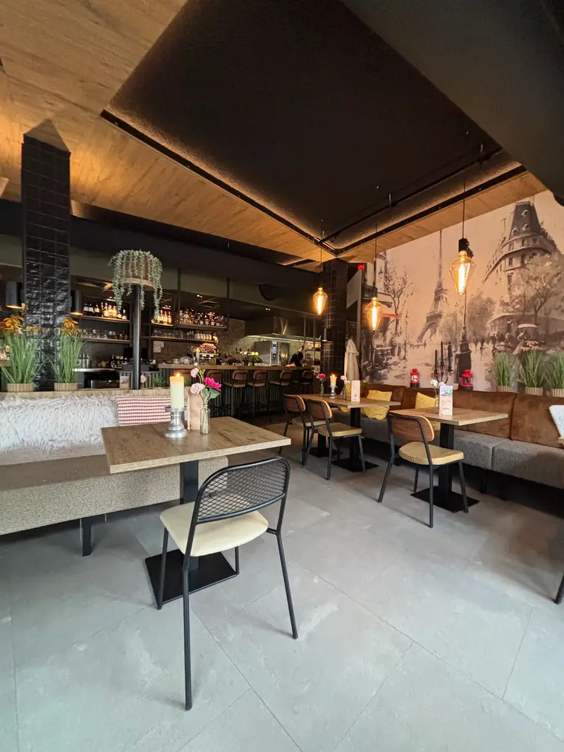 Het interieur van La Bistro met de Parijse muurschildering